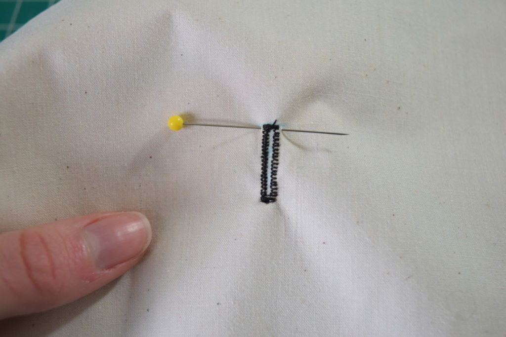 place a pin at the end of the buttonhole