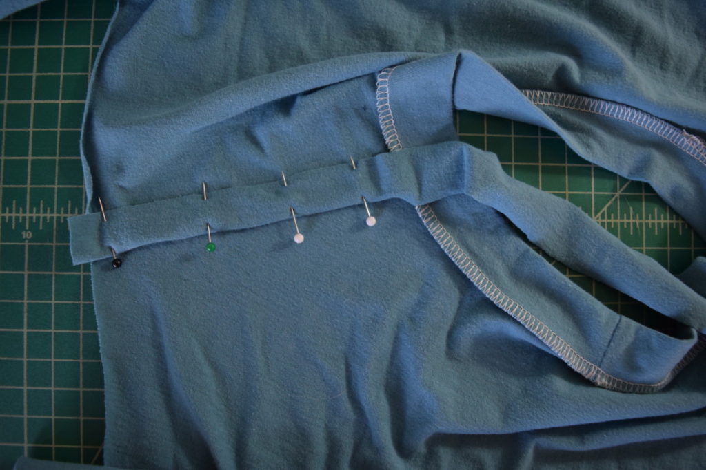 fold the rest of the strip over the serging and pin it in place