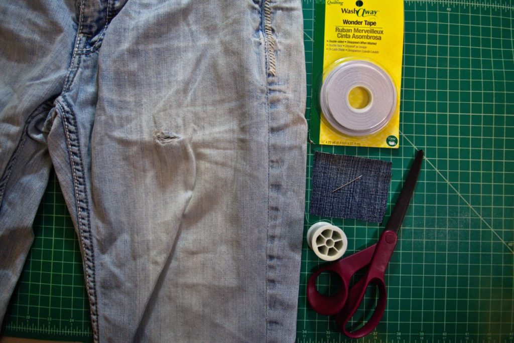 jeans with hole beside supplies to patch hole