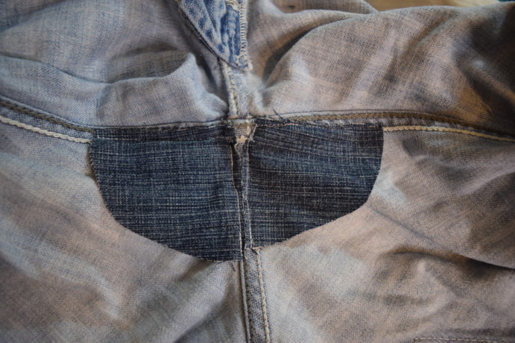two triangular patches are sewn into the back crotch of the jeans 