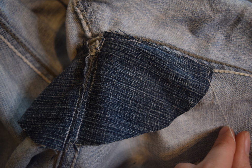 take a small stitch from the outside of the jeans into the patch