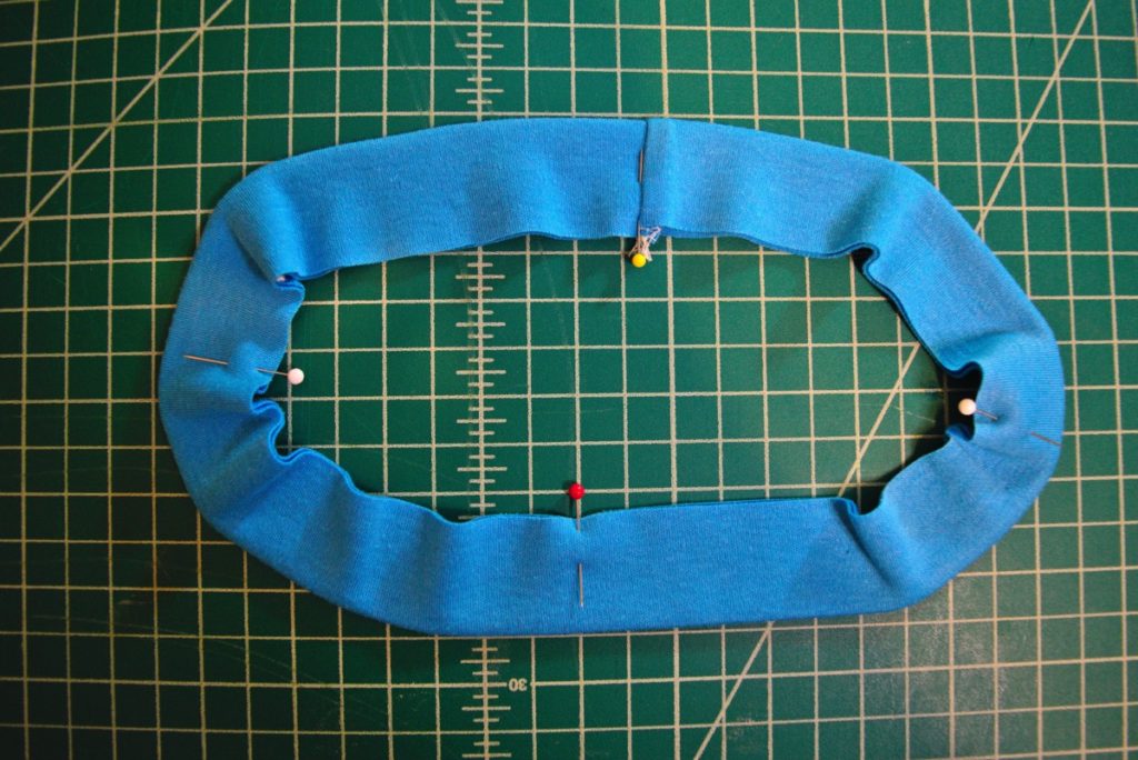 neckband shown laid flat in an oval shape to show four equally spaced pins