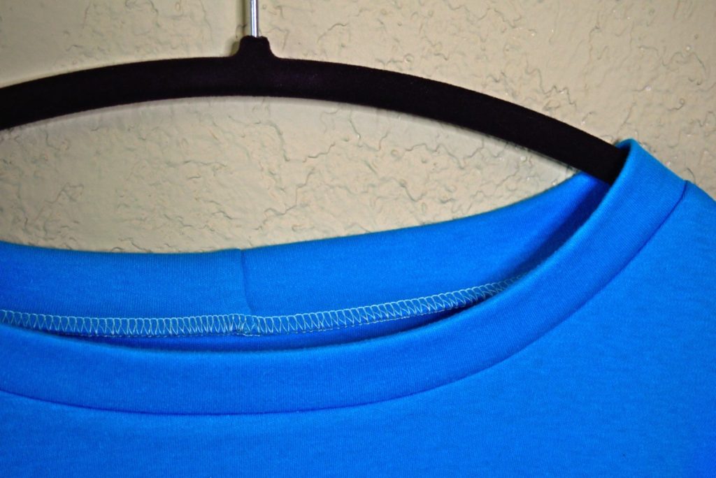a close up of half of a knit neckband sewn with white serging