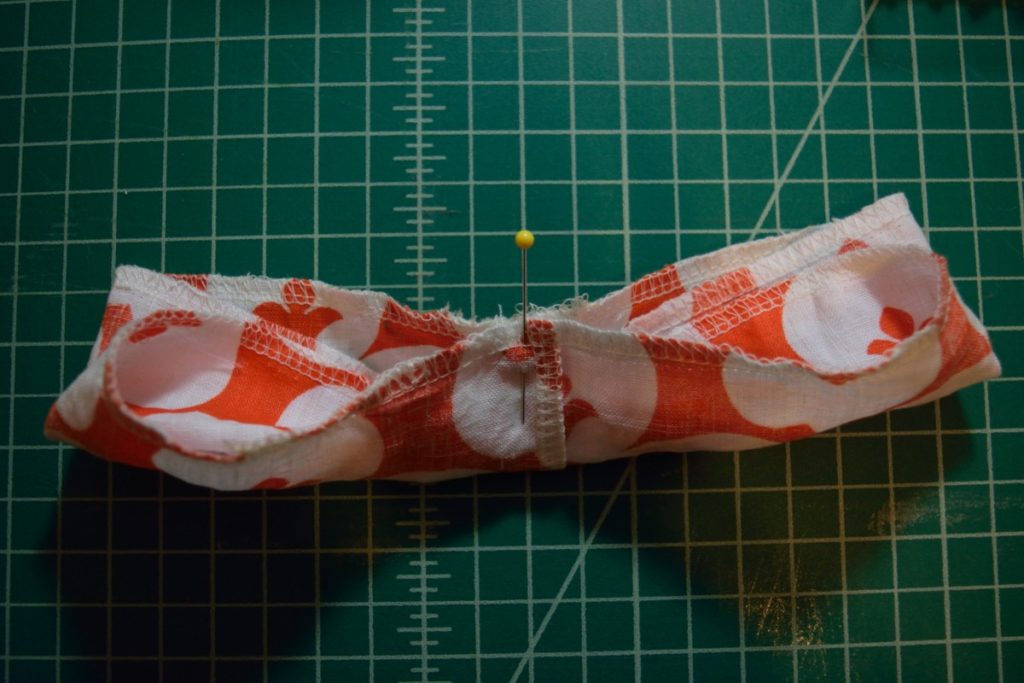 scrunchie is folded and held in place by a pin