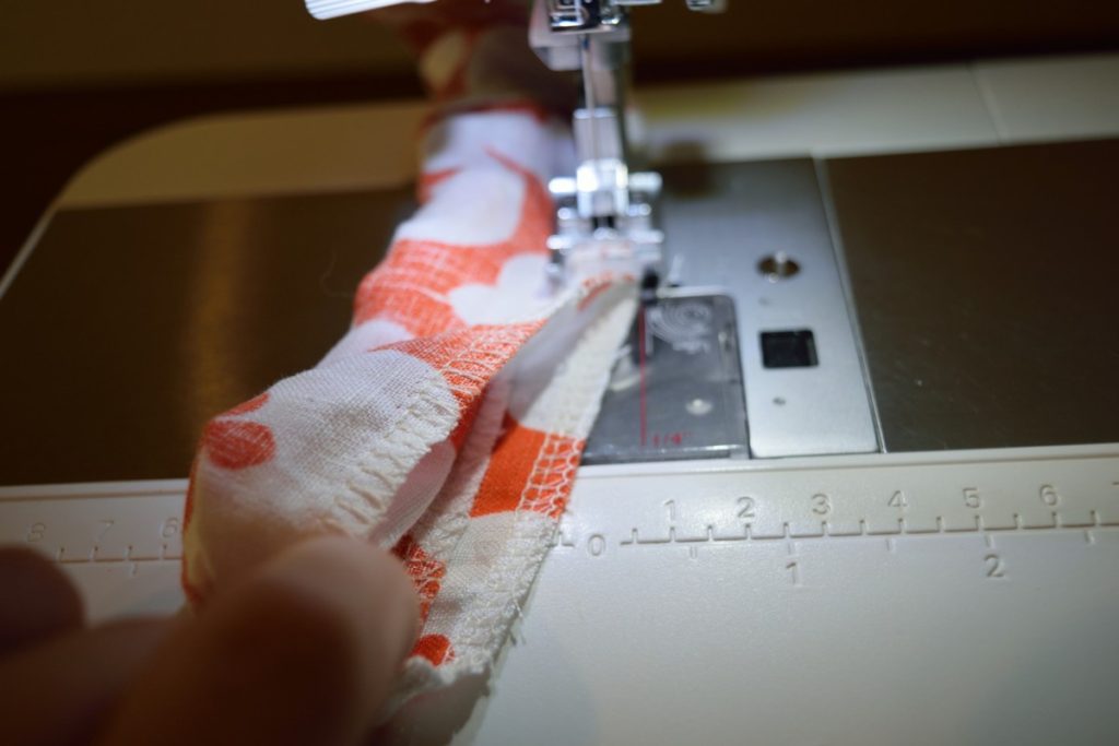 pulling fabric out from inside the scrunchie further in front of the sewing machine foot