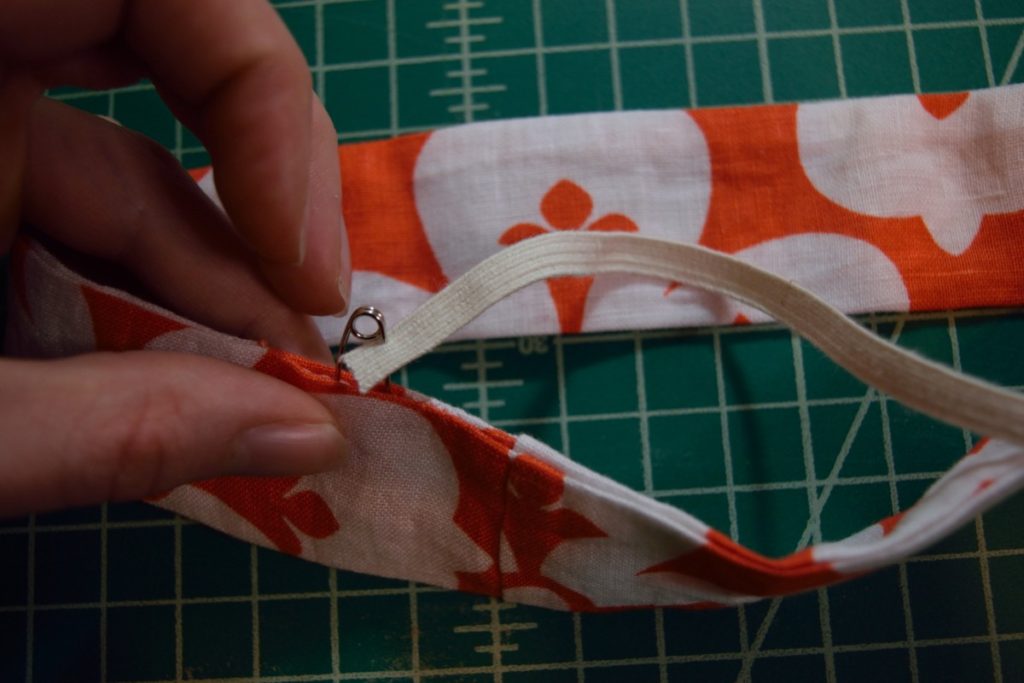 elastic is being inserted into the scrunchie with a safety pin through the gap