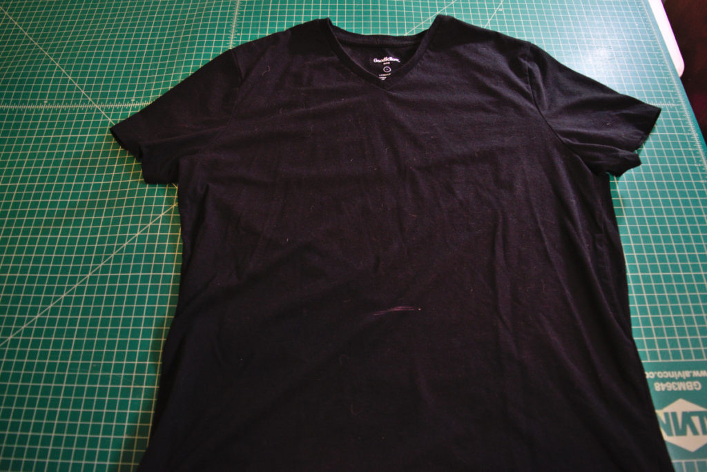 black t shirt on cutting mat with pink chalk marking at center front