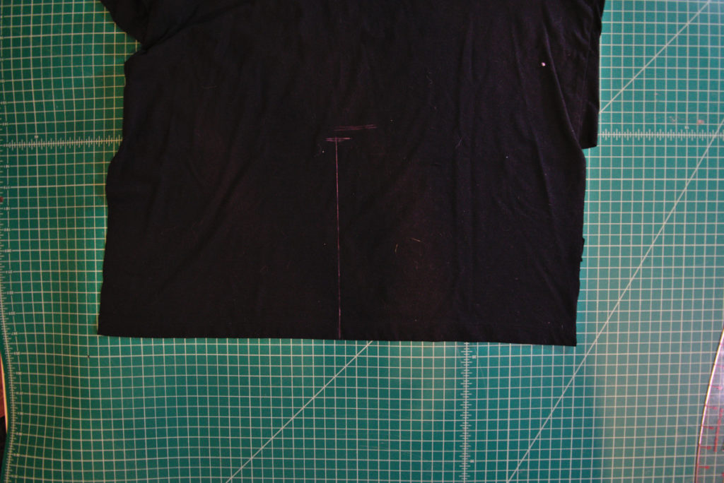 a straight pink chalk line drawn about halfway up the center of the shirt