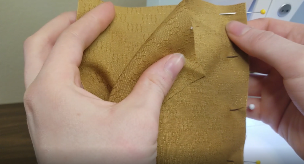 mustard fabric is pinned right sides together to prepare for sewing