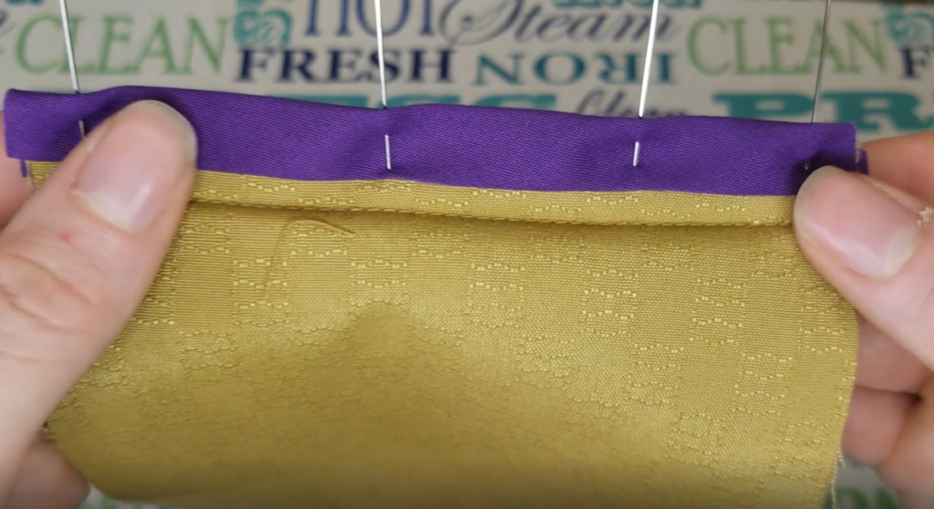 purple bias tape pinned around the seam allowance on mustard fabric