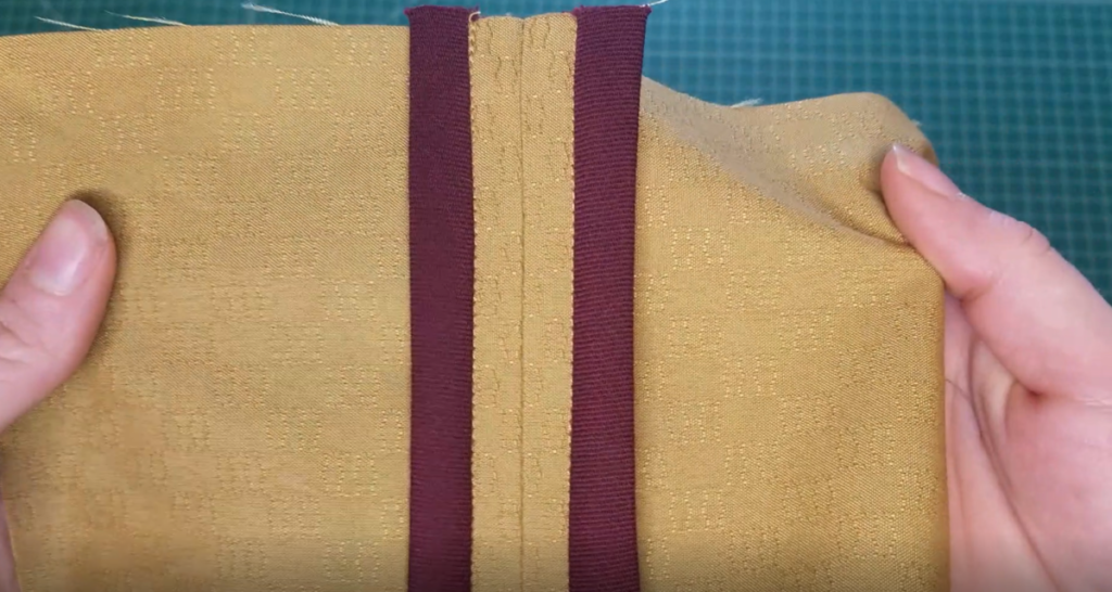 a hong kong seam with contrasting burgundy fabric against a mustard cotton