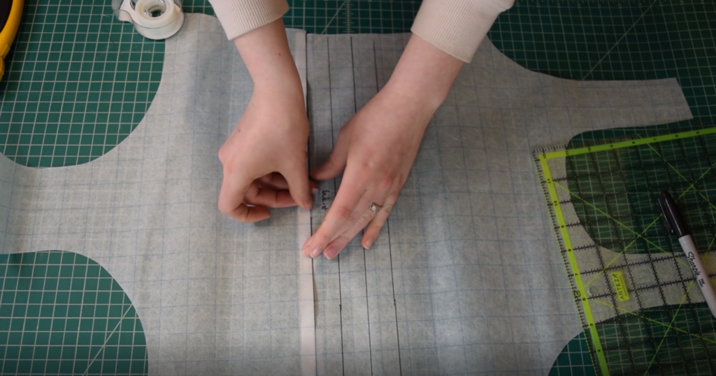 tape the fold in place, 1 inch is taken out of a one piece swimsuit pattern below the waist