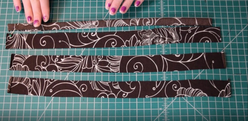 folding the strips of fabric in half lengthwise with right sides together
